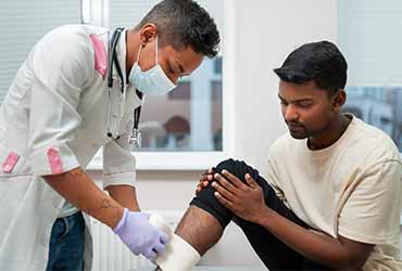 Male nurse helping patient with post-hospitalization care