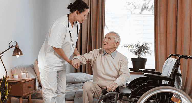 Professional nurse from Caringhand Healthcare assisting elderly patient with wheelchair mobility and care
